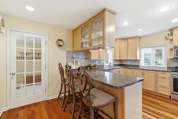 a kitchen with granite countertop a table chairs stove microwave and cabinets