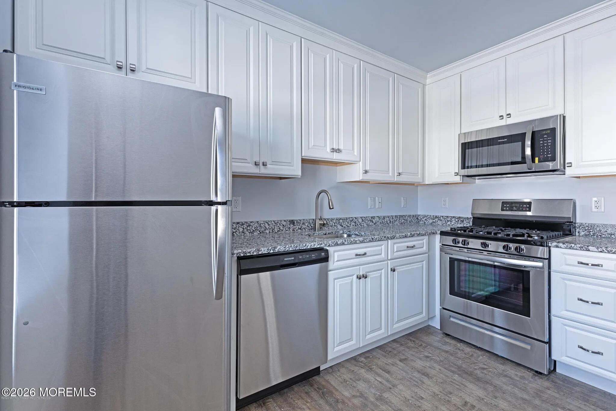 a kitchen with stainless steel appliances granite countertop a stove a refrigerator and a microwave