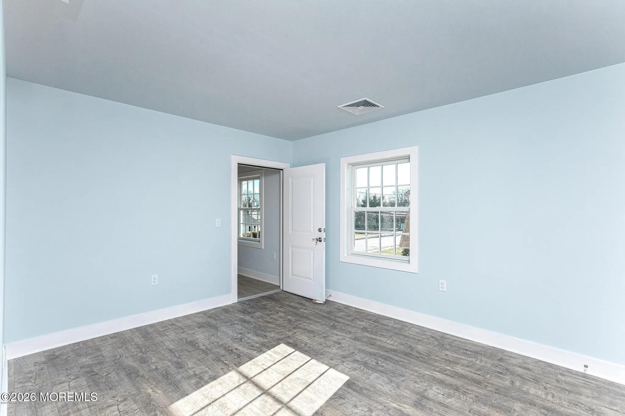 1009 Arnold Avenue, Unit 2A Point Pleasant, NJ 08742 - Photo 4 of 13 a view of an empty room with wooden floor and a window