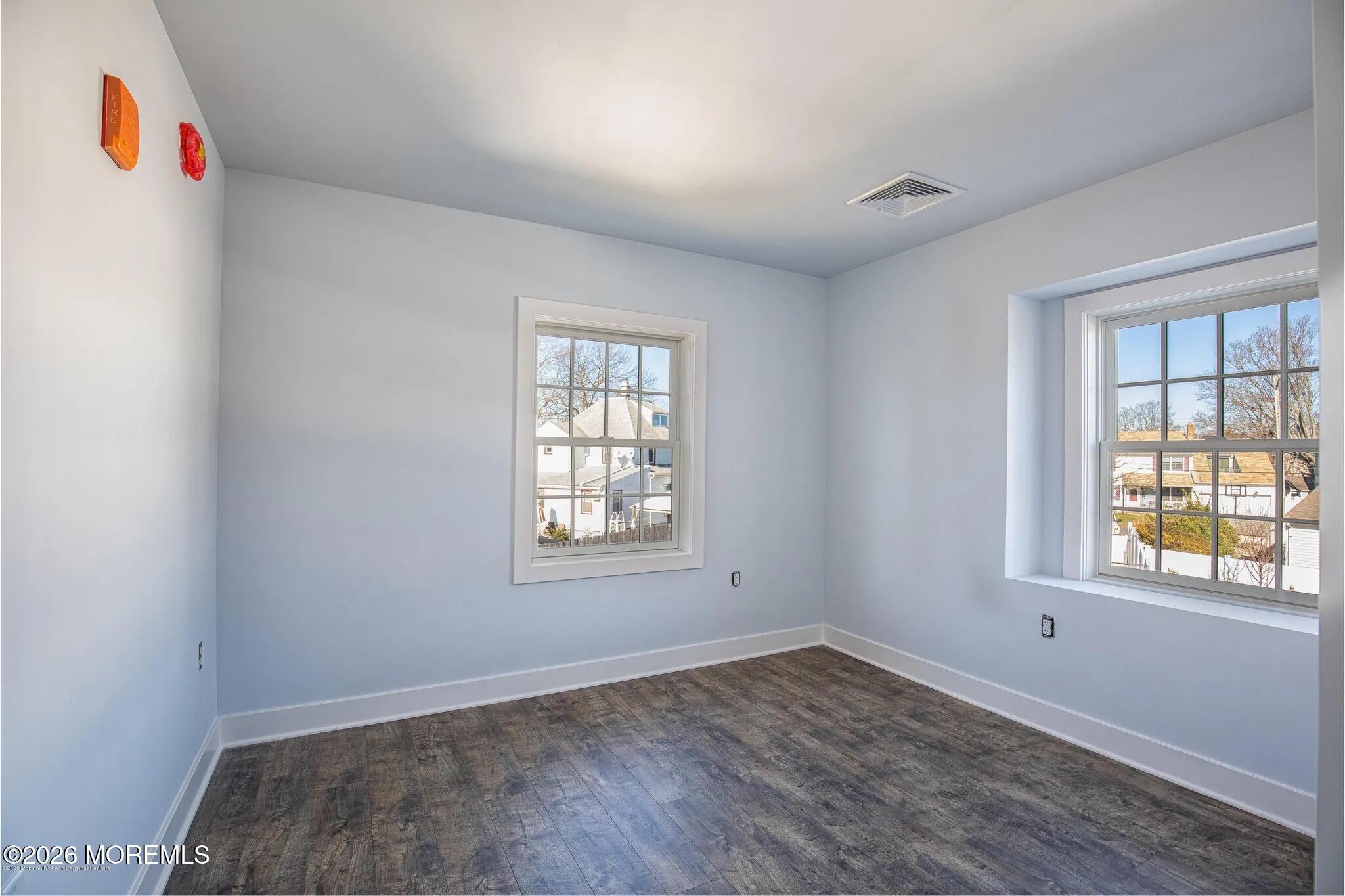 1009 Arnold Avenue, Unit 2A Point Pleasant, NJ 08742 - Photo 9 of 13 an empty room with wooden floor and windows