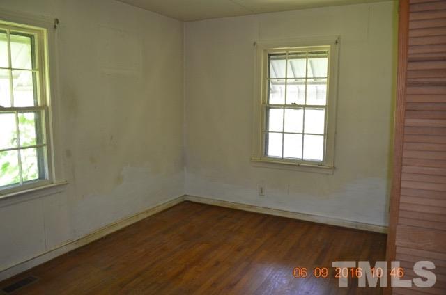 705 Penn Road Raleigh, NC 27604 - Photo 4 of 7 an empty room with wooden floor and windows