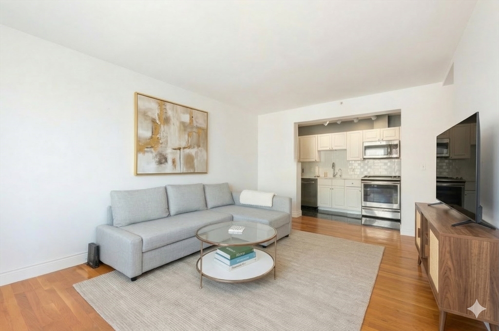 4 Charlesgate East, Unit 703 Boston, MA 02215 - Photo 3 of 15 a living room with furniture a flat screen tv and a refrigerator