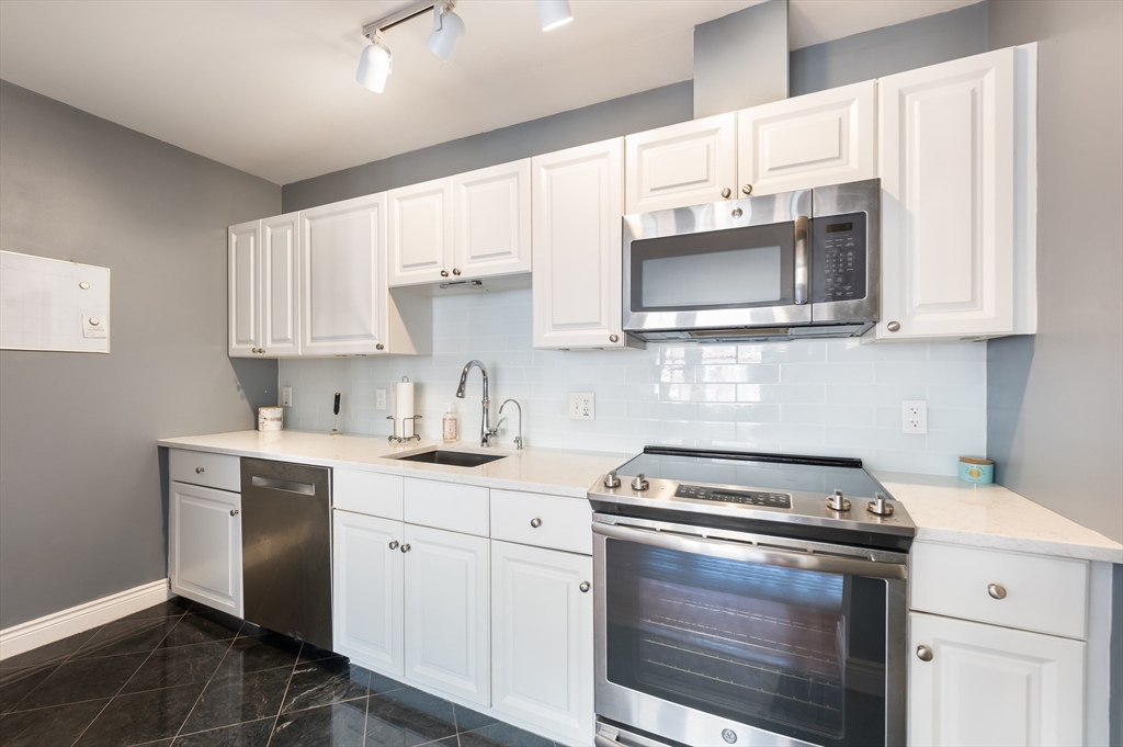 4 Charlesgate East, Unit 703 Boston, MA 02215 - Photo 5 of 15 a kitchen with cabinets stainless steel appliances a sink and a stove