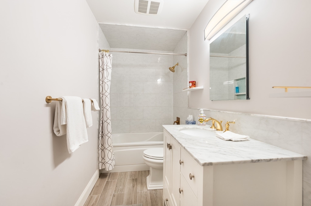 4 Charlesgate East, Unit 703 Boston, MA 02215 - Photo 6 of 15 a bathroom with a granite countertop sink a toilet and a large mirror