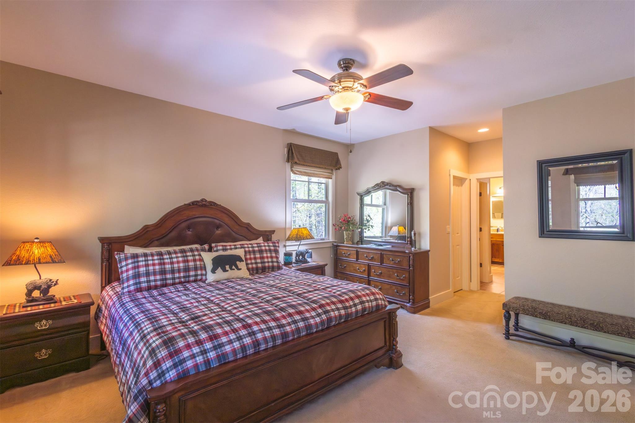 82 Mdw Rdg Court Tuckasegee, NC 28783 - Photo 17 of 39 a bedroom with a large bed a chandelier and dresser