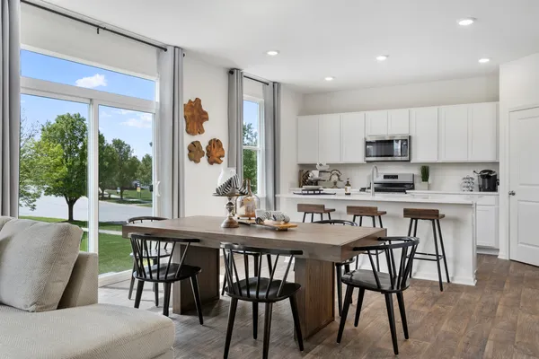 a kitchen with kitchen island a dining table and chairs