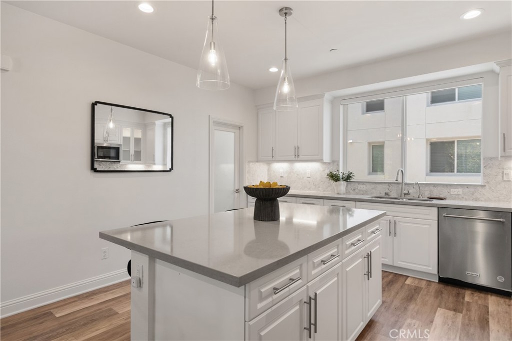 161 Steely Irvine, CA 92614 - Photo 8 of 35 a kitchen with stainless steel appliances granite countertop a sink a stove and a wooden floor