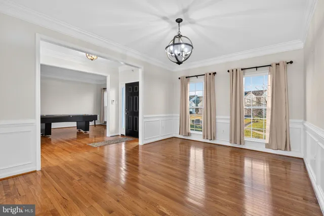a view of staircase with lots of frames on wall and wooden floor