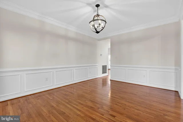 a view of an empty room with wooden floor fireplace and a window