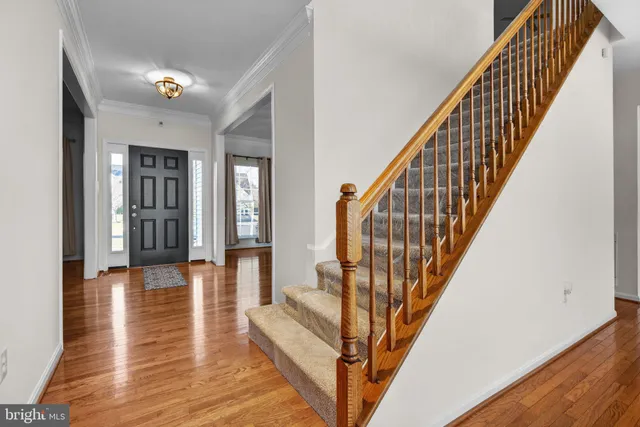 a kitchen with stainless steel appliances granite countertop a stove a sink dishwasher and a refrigerator with wooden floor