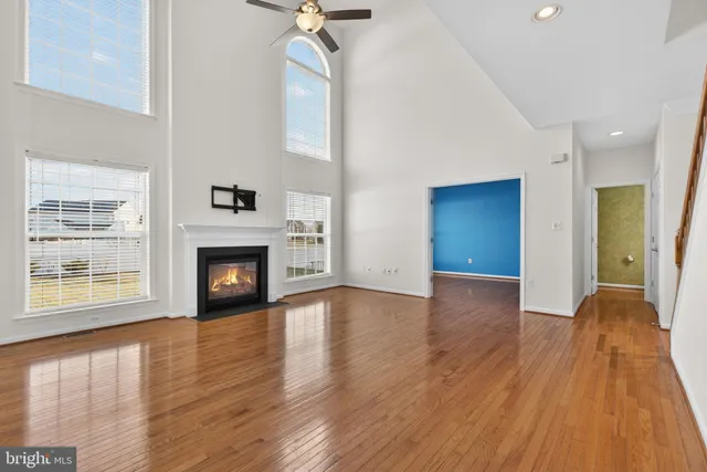 a view of a livingroom with wooden floor and a ceiling fan