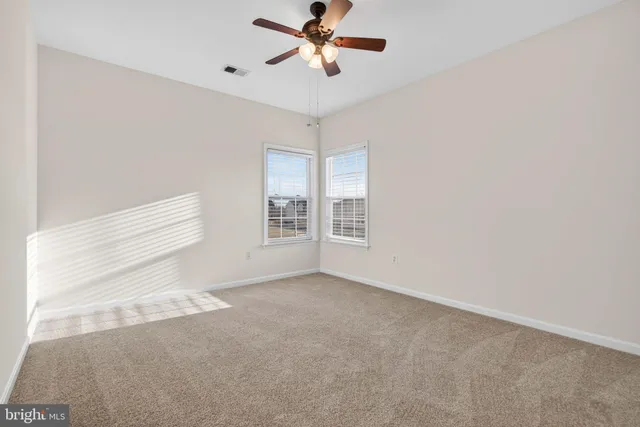 a bedroom with a large bed a flat screen tv and windows