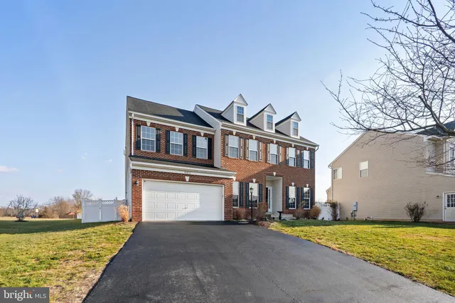 a front view of a house with a yard and lake view