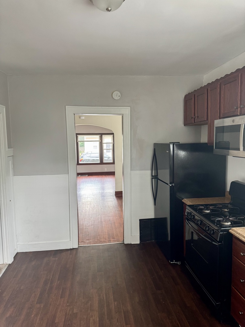 118 Wilcox Avenue Elgin, IL 60123 - Photo 11 of 29 a kitchen with a refrigerator and a stove top oven