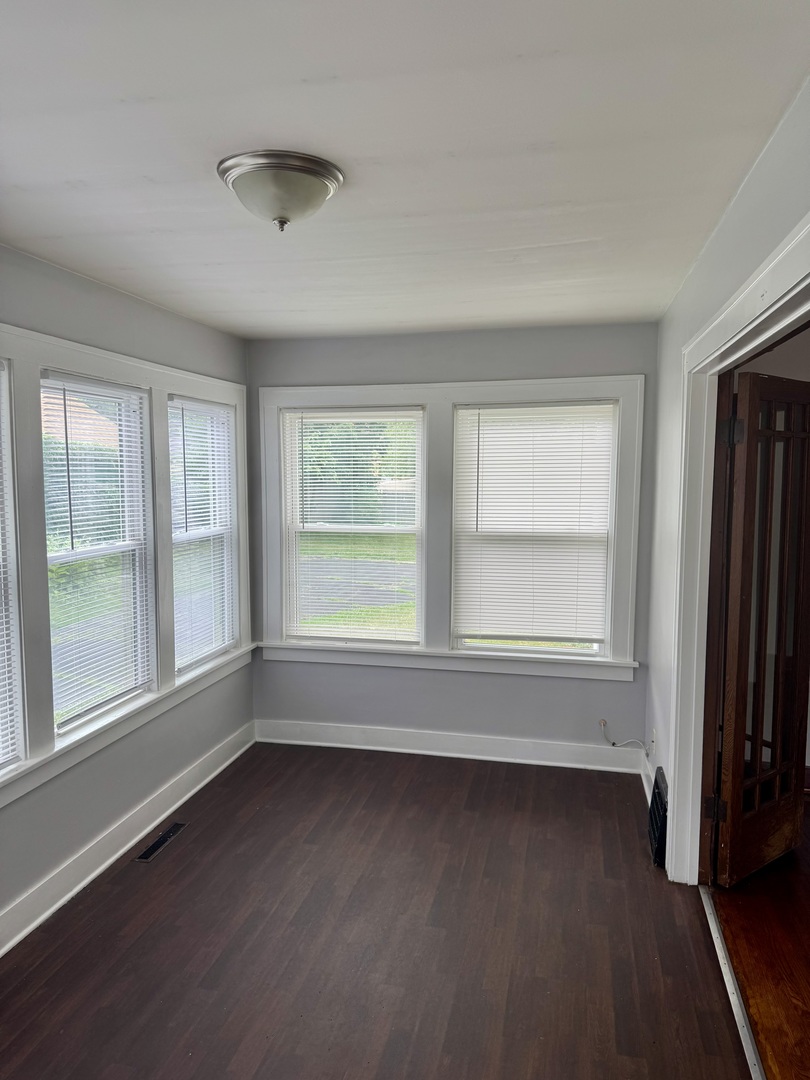118 Wilcox Avenue Elgin, IL 60123 - Photo 2 of 29 an empty room with wooden floor and windows