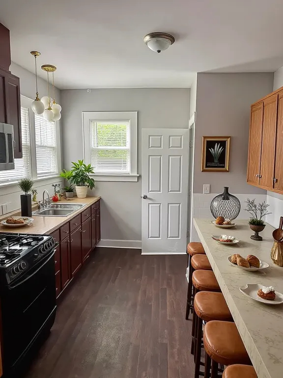 118 Wilcox Avenue Elgin, IL 60123 - Photo 10 of 29 a kitchen with stainless steel appliances kitchen island granite countertop a stove a sink dishwasher and white cabinets with wooden floor