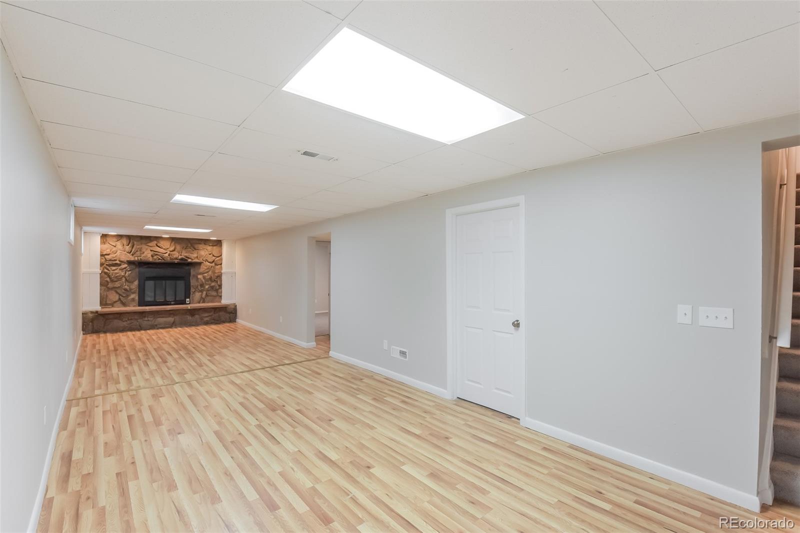 5522 Carson Street Denver, CO 80239 - Photo 9 of 17 wooden floor in an empty room with a fireplace