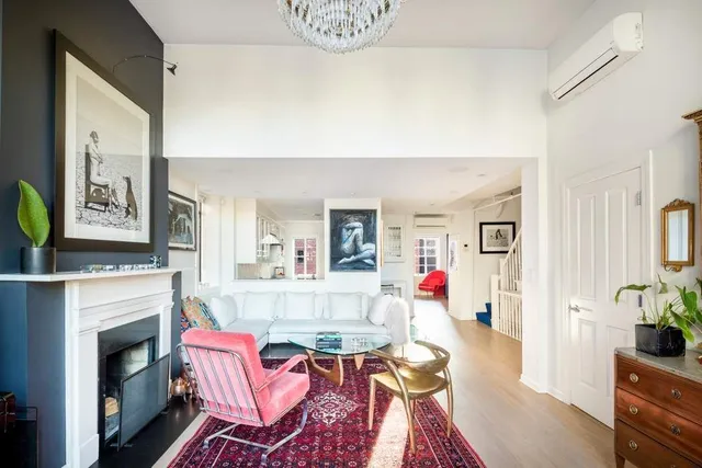 a living room with furniture large window and wooden floor