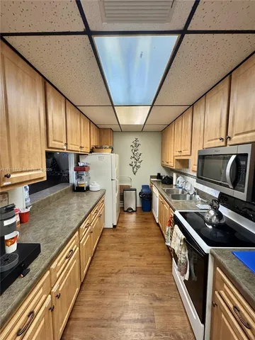 a dining hall with stainless steel appliances granite countertop a stove and wooden floors