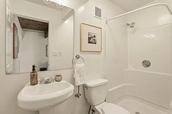 a bathroom with a sink a toilet and shower