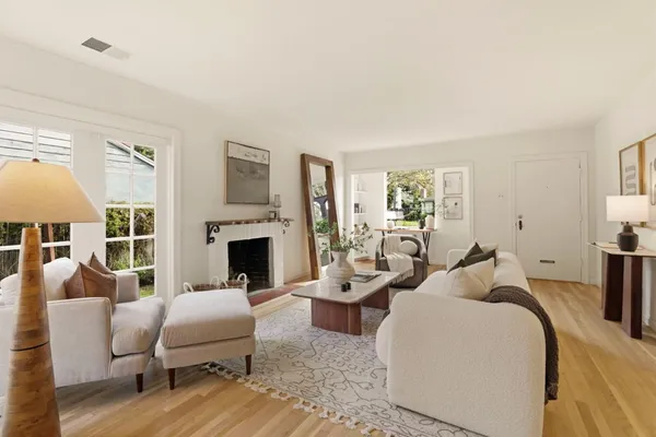 a living room with furniture a fireplace and a large window