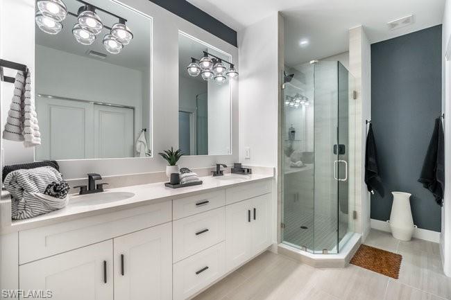 16907 Fairgrove Way, Unit 201 Naples, FL 34110 - Photo 13 of 28 a bathroom with double sink and a mirror
