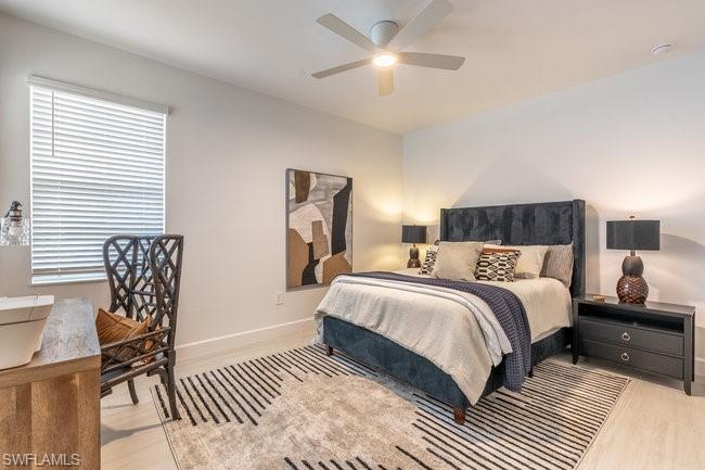 16907 Fairgrove Way, Unit 201 Naples, FL 34110 - Photo 16 of 28 a bedroom with a bed and a chandelier