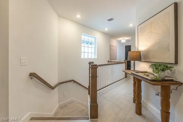 a kitchen with stainless steel appliances granite countertop a dining table chairs refrigerator and microwave