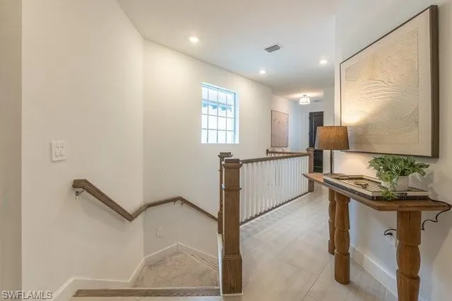 a kitchen with stainless steel appliances granite countertop a dining table chairs refrigerator and microwave