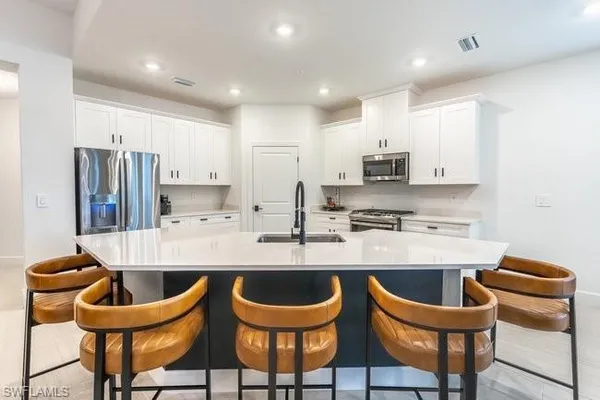 a kitchen with stainless steel appliances granite countertop a sink a stove and a wooden cabinets