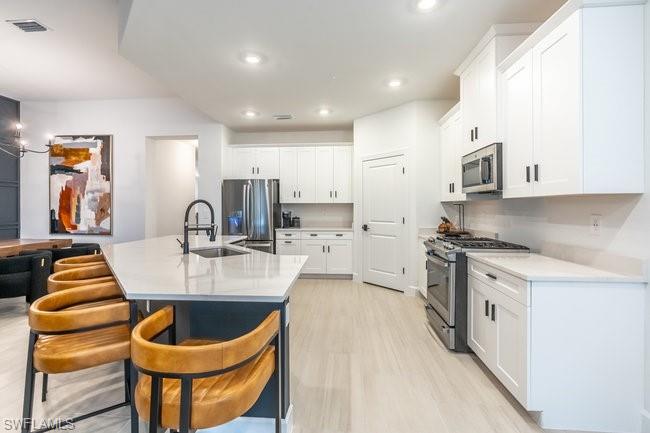 16907 Fairgrove Way, Unit 201 Naples, FL 34110 - Photo 7 of 28 a kitchen with stainless steel appliances granite countertop a sink a stove and a wooden cabinets