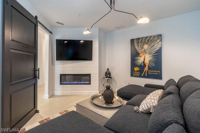 16907 Fairgrove Way, Unit 201 Naples, FL 34110 - Photo 10 of 28 a living room with furniture and a flat screen tv