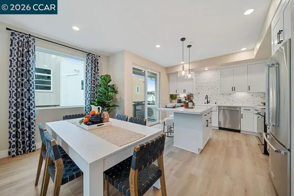 a kitchen with a table chairs refrigerator and cabinets