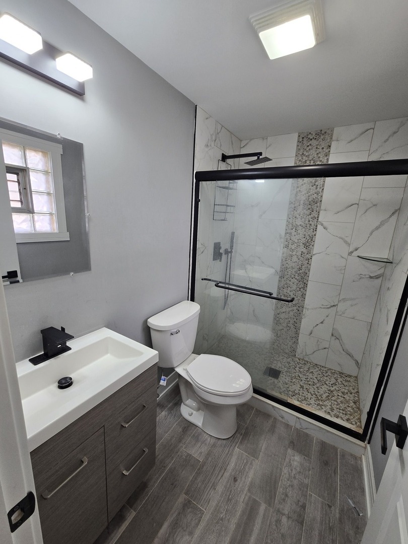 6024 Birmingham Street Chicago Ridge, IL 60415 - Photo 19 of 21 a bathroom with a sink a toilet and shower
