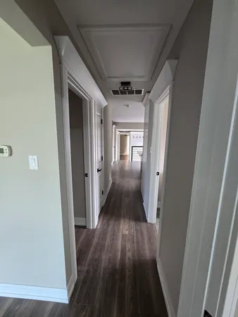 a kitchen with a wooden floor and electronic appliances