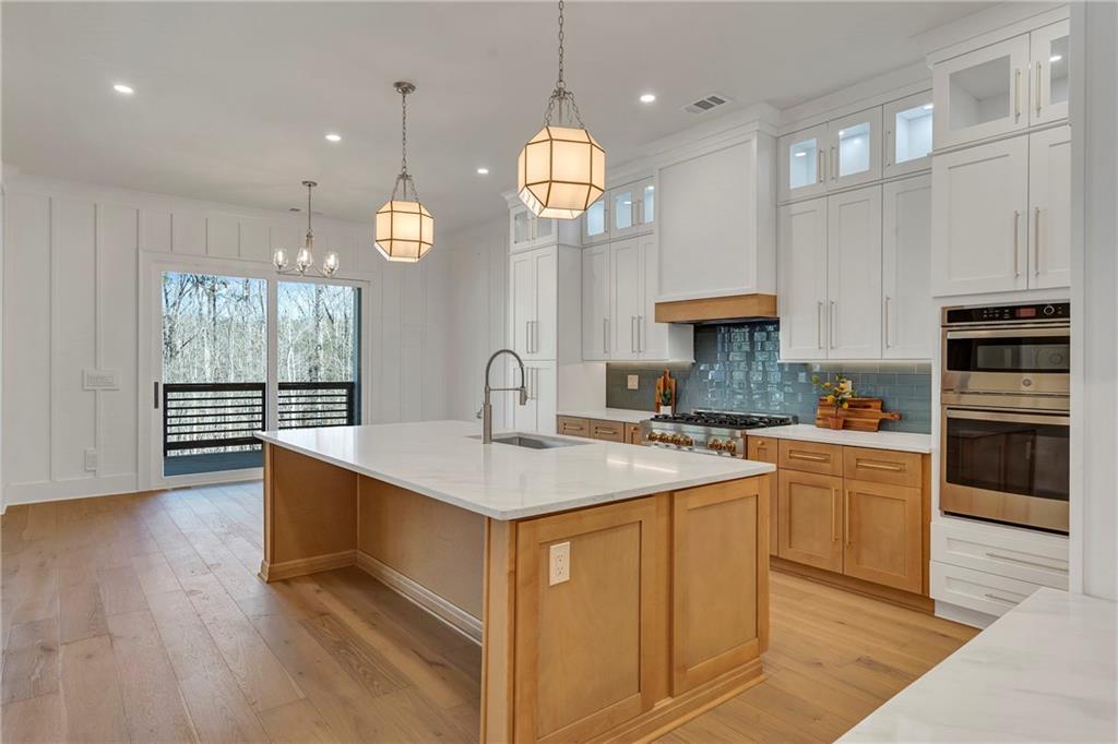 3610 Fleming Drive Cumming, GA 30041 - Photo 12 of 51 a open kitchen with stainless steel appliances granite countertop a stove a sink dishwasher and a fireplace with wooden floor