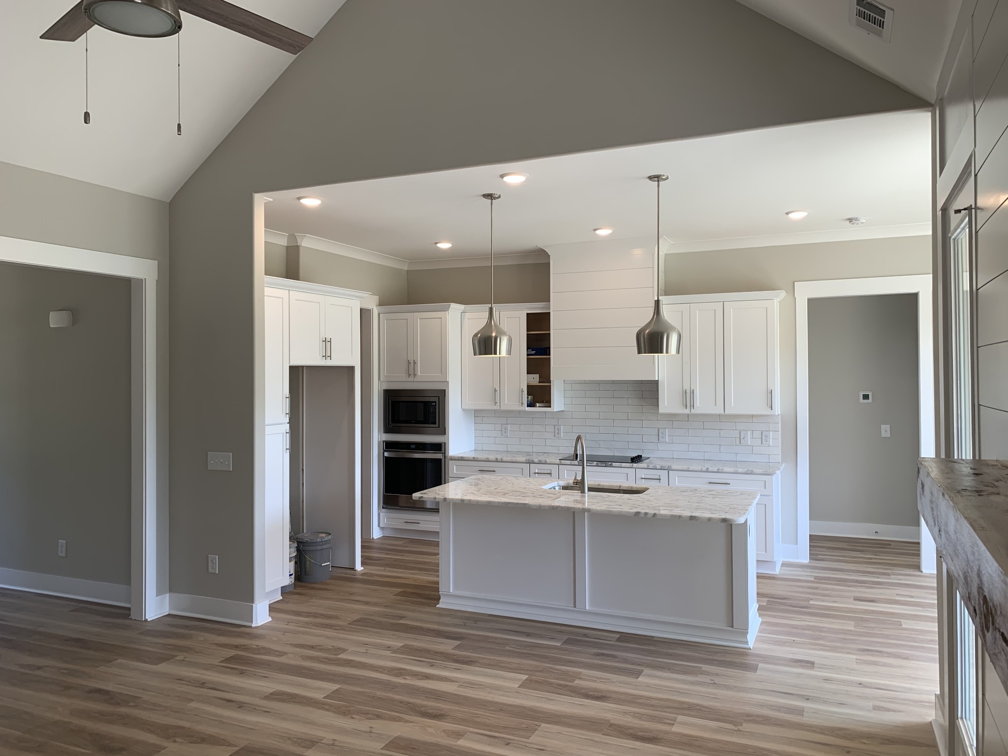 1810 Old Gallatin Road Portland, TN 37148 - Photo 37 of 52 a large white kitchen with a large kitchen island white cabinetry and wooden floor