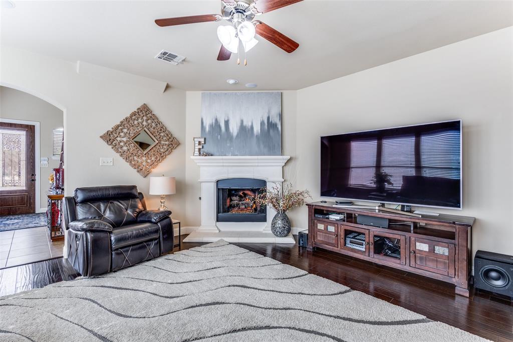 817 Deer Ridge Trail McKinney, TX 75072 - Photo 6 of 35 Family Room with wood flooring wall of windows and gas fireplace