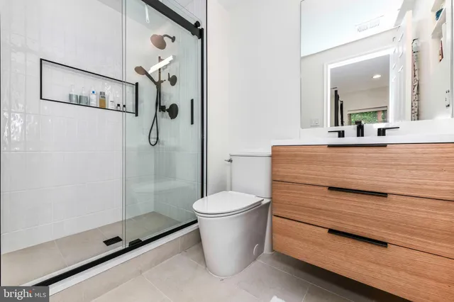 a bathroom with a granite countertop toilet a sink and shower