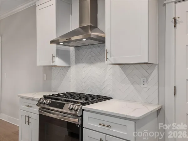 a white stove top oven sitting inside of a kitchen
