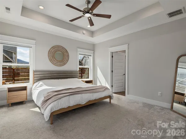 a bedroom with a bed a window and a chandelier