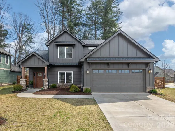 a front view of house with yard and trees in the background