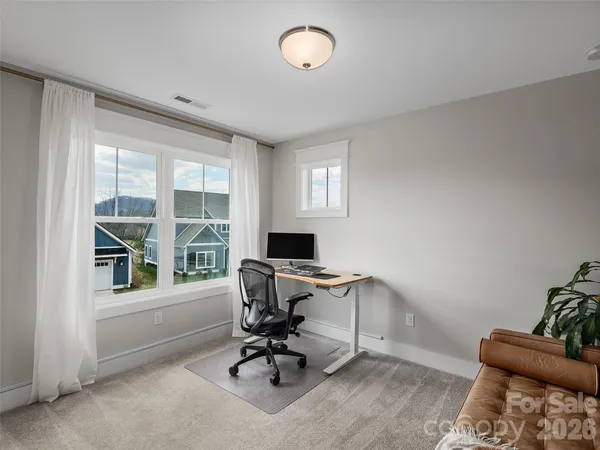 a view of a workspace with furniture and a window