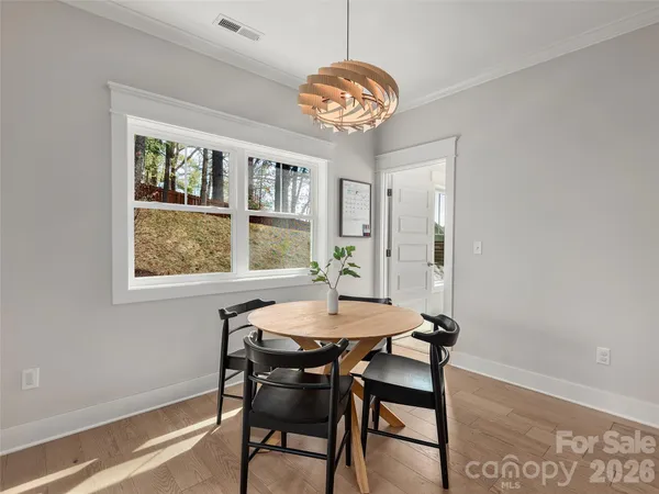 a dining room with window a chandelier and wooden floor