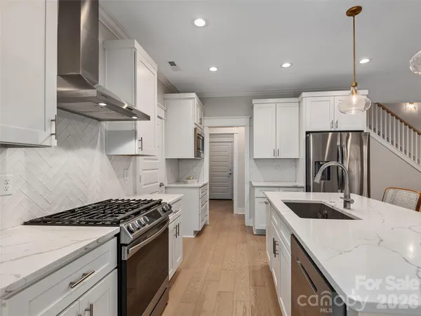 a kitchen with kitchen island a sink stove and refrigerator