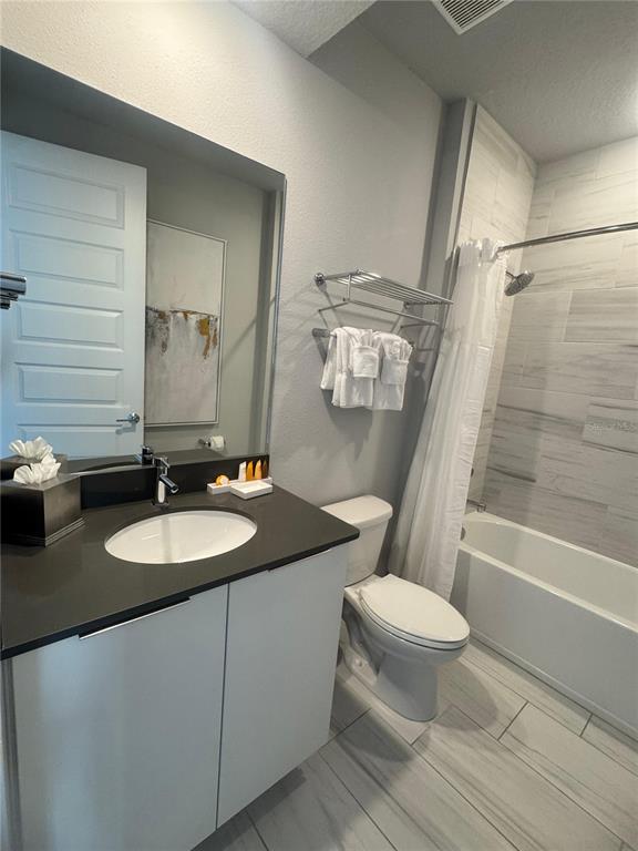 7770 Sandy Ridge Drive, Unit 210 Reunion, FL 34747 - Photo 30 of 42 a bathroom with a granite countertop sink toilet a mirror and bathtub