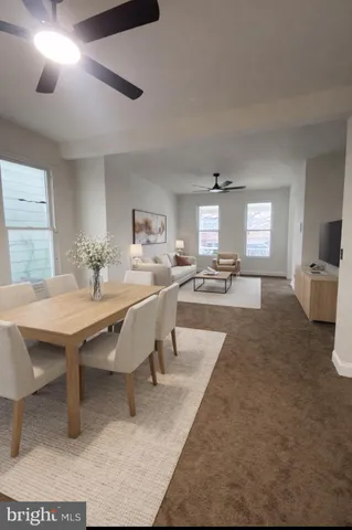 a dining hall with stainless steel appliances kitchen island granite countertop a dining table and chairs