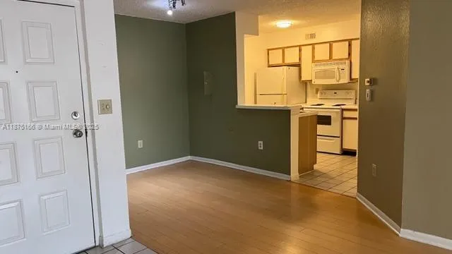 a view of a kitchen with an empty space and a window