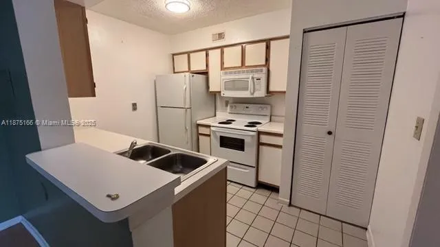 a view of kitchen with white cabinets and white appliances