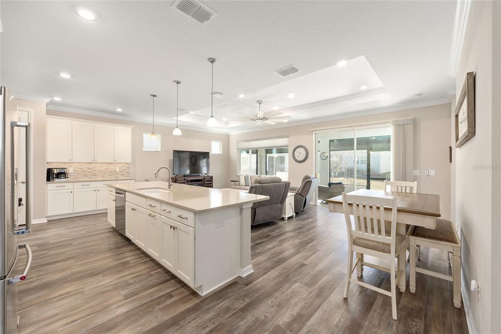 10390 Southwest 99th Street Ocala, FL 34481 - Photo 19 of 48 a large kitchen with cabinets wooden floor and stainless steel appliances
